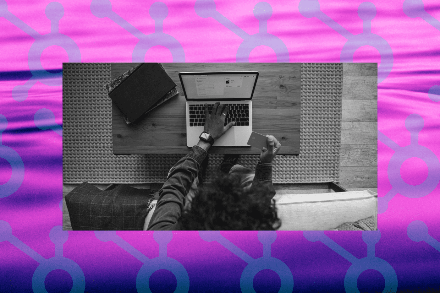 Black and white photo of a person using their credit card to make an online donation. This is stacked on a purple background with the HubSpot logo repeating, signifying a connection to utilizing HubSpot for fundraising.