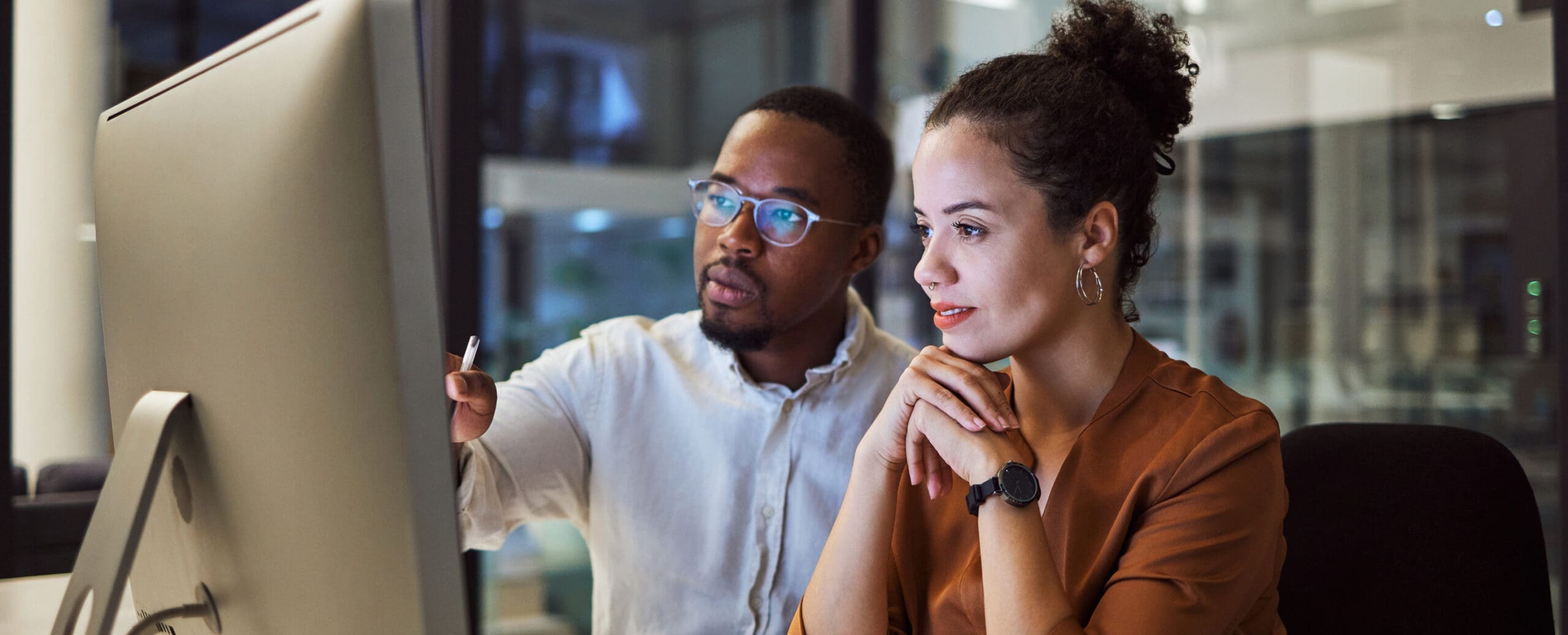 A man and woman search for information on a computer